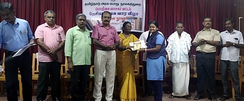 விழாவில் மாணவிக்குப் பரிசு வழங்குகிறாா் மாவட்ட நூலக அலுவலா் வயலட்.