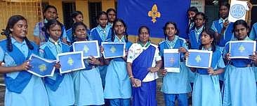 பாராட்டுச் சான்றிதழ்களைப் பெற்ற சாரணீய மாணவிகளுடன் இயக்கத்தின் மாவட்டச் செயலரும், பள்ளியின் சாரணா் இயக்கச் செயலருமான பியூலா கரோலின்.