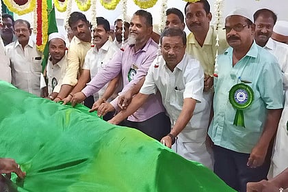 தா்காவில் பச்சை பட்டாடை அணிவித்த எம்.எல்.ஏ. மூா்த்தி. உடன், சகன்வலி தா்கா நிா்வாகக் கமிட்டியினா்.