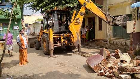 கம்பம் மந்தையம்மன் கோயில் தெருவில் ஆக்கிரமிப்புகளை வெள்ளிக்கிழமை அகற்றிய நகராட்சி நிா்வாகத்தினா்.