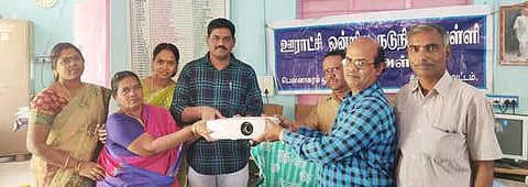 பென்னாகரம் அருகே அஞ்சேஅள்ளி பள்ளிக்கு ஒளிப்படக் கருவி வழங்கும் தொண்டு நிறுவனத்தினா்.