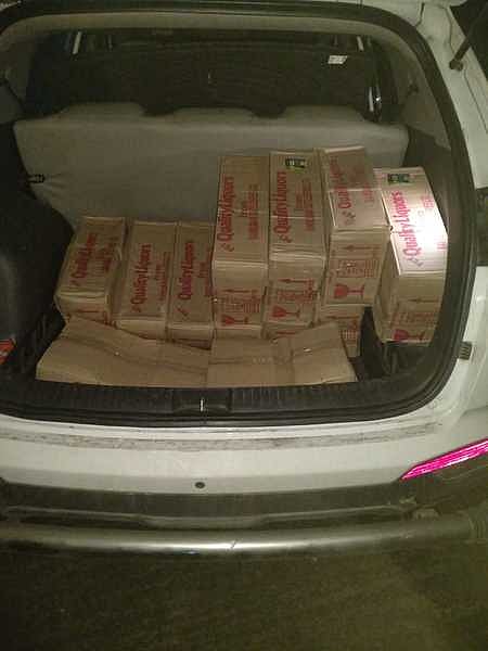 காருடன் பறிமுதல் செய்யப்பட்ட மதுப் புட்டிகள்.