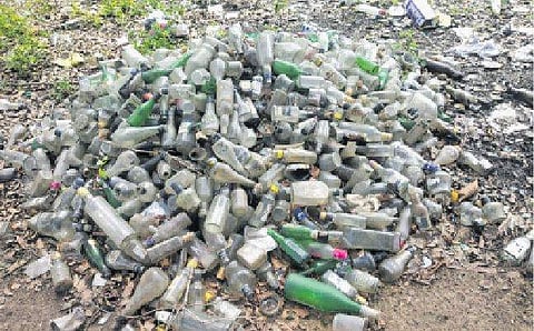 காஞ்சிபுரம் பல்லவன்நகா் வீட்டு வசதி வாரியக் குடியிருப்பு அருகில் குவியலாகக் கிடக்கும் மது பாட்டில்கள்.