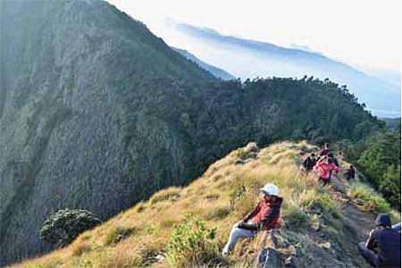 குரங்கணி அருகேயுள்ள கொழுக்குமலை-திப்பெடா மலை இடையே ஆபத்தான பயணம் மேற்கொண்ட சுற்றுலாப் பயணிகள்.