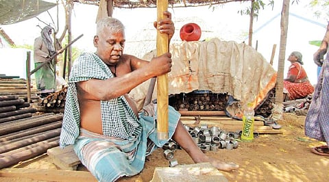 உலக்கையை பாலிஷ் செய்யும் பணியில் ஈடுபட்டுள்ள தொழிலாளி.