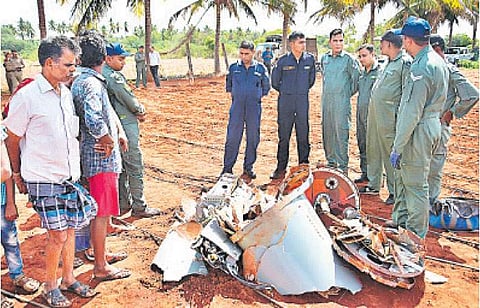 இருகூர்-குரும்பபாளையம் இடையே விவசாய நிலத்தில் விழுந்து கிடக்கும் தேஜஸ் ரக விமானத்தின் எரிபொருள் டேங்க் உதிரி பாகங்களை பார்வையிடும் விமானப்படை அதிகாரிகள்.