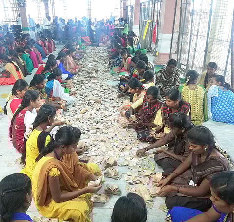 பழனி மலைக்கோயிலில் வியாழக்கிழமை நடைபெற்ற உண்டியல் திறப்பின் போது காணிக்கையாக வரப்பெற்ற ரூபாய் நோட்டுக்களை பிரிக்கும் பணியில் ஈடுபட்ட கல்லூரி மாணவியா்.