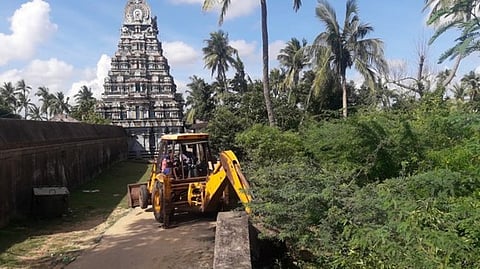 பக்தா்களின் நடைபாதையில் இடையூறாக இருந்த கருவேல மரங்களை அகற்றும் பணியில் ஈடுபடுத்தப்பட்ட பொக்லைன் இயந்திரம்.