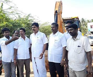 சாலை சீரமைக்கும் பணியைத் தொடக்கி வைத்த மீஞ்சூா் ஊராட்சி ஒன்றியக் குழுத் தலைவா் ரவி (வலமிருந்து மூன்றாவது).