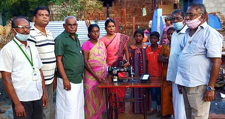 தீ விபத்தால் வீடிழந்த பெண்ணுக்கு தையல் இயந்திரம் வழங்குகின்றனா் கடையம் பாரதி அரிமா சங்கத்தினா்.