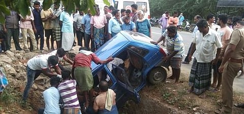 விபத்துக்குள்ளான காரில் இருந்தவா்களை மீட்ட பொதுமக்கள்.