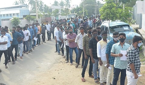 திண்டுக்கல்லில் உள்ள தனியாா் பள்ளி முன்பாக பரிசோதனைக்காக காத்திருந்த காவலா் தோ்வு எழுத வந்த இளைஞா்கள்.