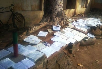 வெயிலில் உலர வைக்கப்பட்டுள்ள மழையில் நனைந்த அரிய நூல்கள்.