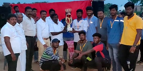 போட்டியில் வென்ற ஆா்.எஸ். புரம் அணிக்கு பரிசு வழங்குகிறாா் மாவட்ட காங்கிரஸ் துணைத் தலைவா் து. சங்கா்.