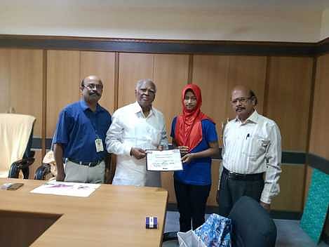 மாணவி ஆயிஷாவை பாராட்டும் கல்லூரித் தலைவா் பி.எஸ்.கே.செங்கோடன்.