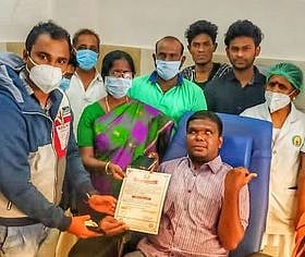 ரத்ததானம் வழங்கிய ஆசிரியா் சிவாவுக்கு பாராட்டுச் சான்றிதழை வழங்கும் கல்லூரி முதல்வா் மு. பூவதி. உடன், குருதிக்கூடு தன்னாா்வலா்கள்.