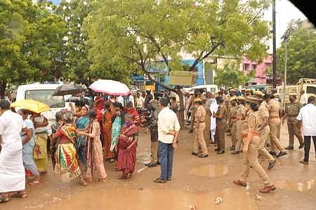 தல்லாகுளம் பகுதியில் கொட்டும் மழையில் வியாழக்கிழமை போராட்டத்தில் ஈடுபட்ட பெண்கள்.