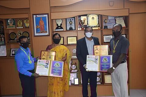 தமிழ்த் துறைப் பேராசிரியா்களைப் பாராட்டும் கல்லூரி முதல்வா் வீ.தியாகராசு.