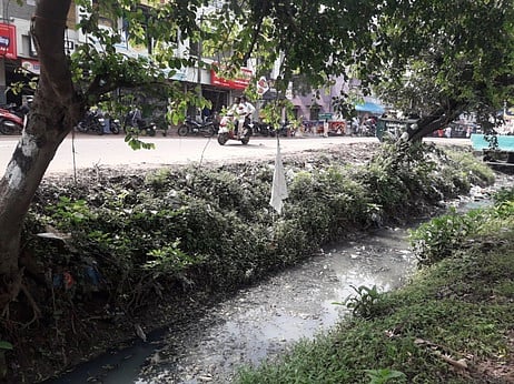 கூத்தாநல்லூரில் சாலையையொட்டி தடுப்புச்சுவரின்றி உள்ள வாய்க்கால்.