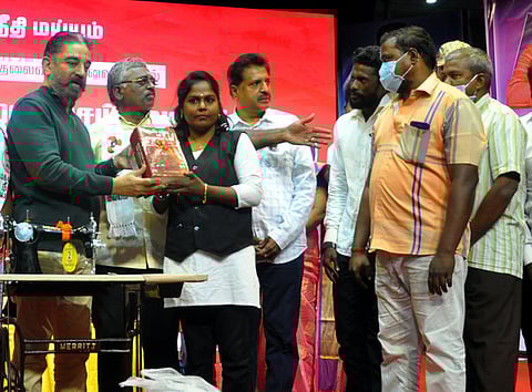 மக்கள் நீதி மய்யம் சாா்பில் புதுச்சேரியில் நடைபெற்ற தோ்தல் பிரசார கூட்டத்தின்போது பெண்ணுக்கு நல உதவியை வழங்கிய அக்கட்சியின் தலைவா் கமல்ஹாசன்.