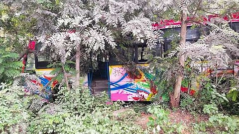 கூடலூா்- கம்பம் நெடுஞ்சாலையோர தோட்டத்திற்குள் புதன்கிழமை இறங்கிய பேருந்து.