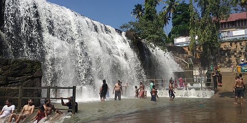 திற்பரப்பு அருவியில் மிதமாகக் கொட்டும் தண்ணீரில் இதமாக நீராடிய சுற்றுலாப் பயணிகள்.