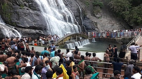 குற்றாலம் பேரருவியில் குளிப்பதற்காக குவிந்த சுற்றுலாப்பயணிகள்.