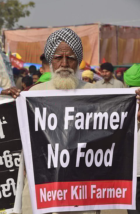 வேளாண் சட்டங்களை எதிர்த்து தில்லி - சிங்கு எல்லையில் 'விவசாயி இல்லை என்றால் உணவு இல்லை, விவசாயிகளைக் கொல்லாதே' என்ற பதாகை ஏந்தி வந்த விவசாயி.