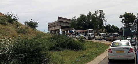 திருச்சி - புதுகை சாலையில் களமாவூா் ரயில்வே மேம்பாலப் பணிகளுக்கு இடையே வரிசையாக நின்று செல்லும் வாகனங்கள்.