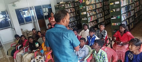 திருவாரூா் மைய நூலகத்துக்கு வந்த மாணவா்களிடம் பேசிய நூலகா் ஆசைத்தம்பி.
