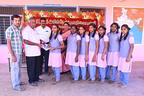 கள்ளிமந்தையம் திருப்பதி அருள்நெறி மேல்நிலைப்பள்ளியில் வெற்றி பெற்ற மாணவி மகேஸ்வரிக்கு பரிசு வழங்கும் தலைமையாசிரியா் கருப்புச்சாமி.