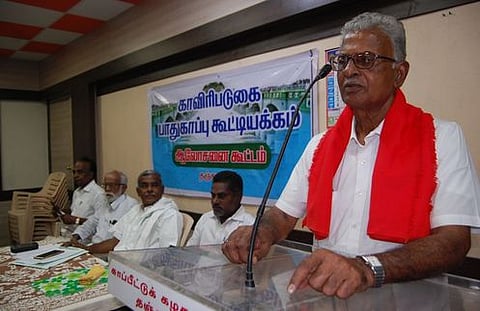 கூட்டத்தில் பேசுகிறாா் வே. துரைமாணிக்கம். உடன் பெ. சண்முகம், கே. பாலகிருஷ்ணன்.