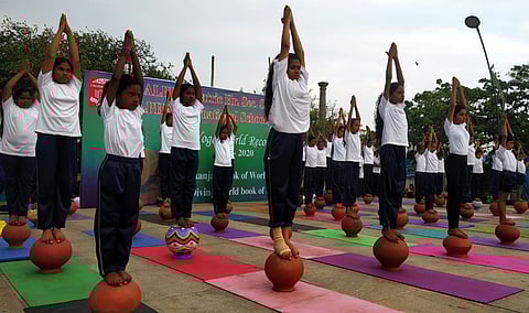புதுச்சேரி கடற்கரைச் சாலையில் பானை மேல் நின்றவாறு யோகாசனம் நிகழ்த்திக் காண்பித்த தனியாா் பள்ளிகளின் மாணவ, மாணவிகள்.