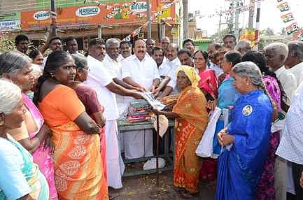 காரமடை ஆசிரியா் காலனியில் பொதுமக்களுக்கு வேட்டி, சேலை வழங்குகிறாா் ஓ.கே.சின்னராஜ் எம்.எல்.ஏ.