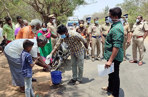 தட்டக்கரை  சோதனைச் சாவடியில்  கைகளைக்  கழுவும்  மலைமக்கள்.