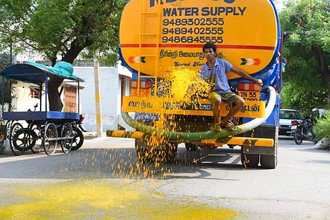 மஞ்சள் நீரை தெளிக்கும் மக்கள்
