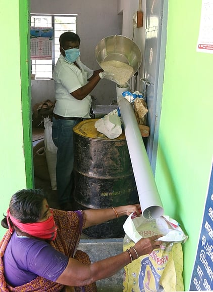 திருவள்ளூரை  அடுத்த  காக்களூா் நியாய விலைக்கடையில் குழாய் பொருத்தி பொருள்களை விநியோகிக்கும் ஊழியா்.