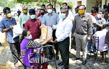 மாற்றுத்திறனாளிகளுக்கு உணவுப் பொருள்கள் வழங்கிய மாவட்ட ஆட்சியா் கு.ராசாமணி, கரோனா தடுப்பு மற்றும் கண்காணிப்பு மண்டல சிறப்புப் பணிக்குழு அலுவலா் ஞானசேகரன்.