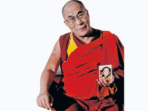 11-ஆவது பஞ்சென் லாமாவின் சிறுவயது புகைப்படத்துடன் தலாய் லாமா.