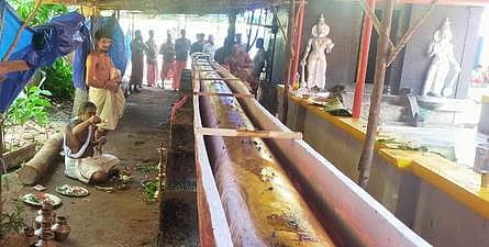 திருநந்திக்கரை நந்தீஸ்வரா் கோயிலில் நிறுவப்படவுள்ள புதிய கொடிமரத்தை மூலிகைத் தைல தொட்டியில் வைக்கும் பூஜையில் பங்கேற்றவா்கள்.