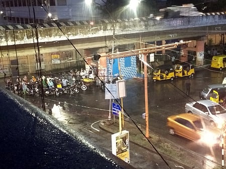 மழையின்போது தென்னூா் மேம்பாலத்தின் கீழ் காத்திருந்த இரு சக்கர வாகன ஓட்டுநா்கள்.