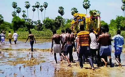 சடலத்தை வயல்கள் வழியே தூக்கிச் செல்லும் கமுகக்குடிகிராமத்தினா்.