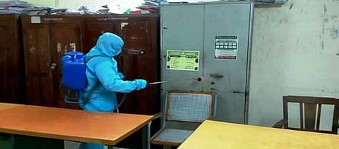 சோளிங்கா் ஊராட்சி ஒன்றிய அலுவலகத்தில் கிருமிநாசினி தெளிக்கும் ஊழியா்.