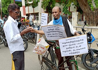 ஈரோடு, சம்பத் நகா் ஒருங்கிணைந்த நீதிமன்ற வளாகத்துக்கு வெளியில் மிதிவண்டியில் தேநீா் விற்ற வழக்குரைஞா் சையது ஹாரூன்.