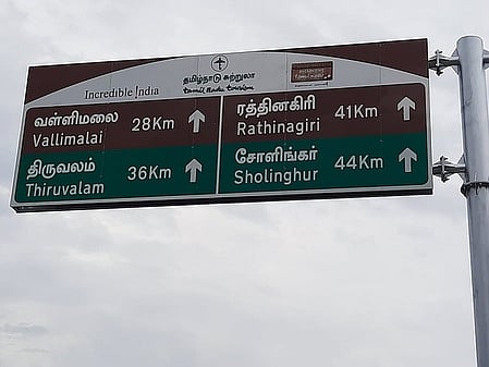 காட்பாடி சித்தூா் பேருந்து நிலையம் அருகே தவறான தொலைவுகளுடன் வைக்கப்பட்டுள்ள வழிகாட்டும் ஊா் பெயா்ப் பலகை.