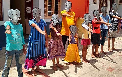 உலக யானைகள் தினத்தை முன்னிட்டு யானை முகக் கவசம் அணிந்து உறுதிமொழி ஏற்கும் நிகழ்ச்சியில் பங்கேற்றோா்.