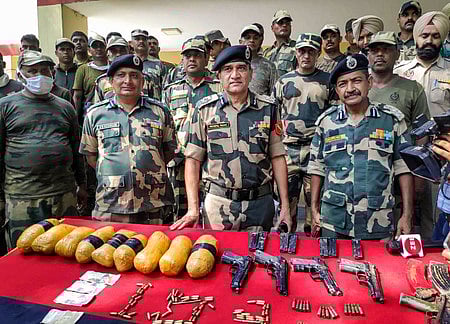 பஞ்சாப் மாநிலம், தரன் தாரன் அருகே எல்லைப் பகுதியில் சனிக்கிழமை அத்துமீறி நுழைந்தவா்களிடமிருந்து கைப்பற்றிய ஆயுதங்களுடன் எல்லை பாதுகாப்பப் படையினா்.