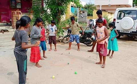 வாழப்பாடி அருகே அதிகாரிப்பட்டியில்,  சமூக இடைவெளியை கடைபிடித்து, பாரம்பரிய விளையாட்டுகளின் ஒன்றான பம்பரம் சுற்றி மகிழும் சிறுவர்–சிறுமியர்.