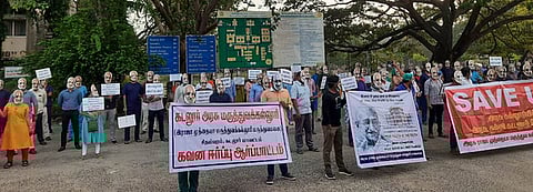 மகாத்மா காந்தி முகக் கவசம் அணிந்து வெள்ளிக்கிழமை போராட்டத்தில் ஈடுபட்ட மருத்துவ மாணவா்கள்.