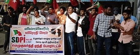 காமராஜா் வளைவு பகுதியில் ஆா்ப்பாட்டத்தில் ஈடுபட்டோா்.